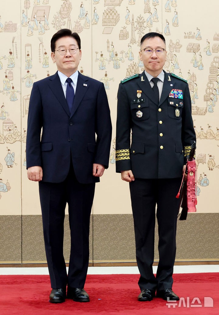 [서울=뉴시스] 김진아 기자= 이재명 대통령이 7일 청와대에서 열린 장성 진급 신고 및 삼정검 수치 수여식에서 이상렬 지상작전사령관(대장)에게 삼정검 수치를 수여한 뒤 기념촬영을 하고 있다. (청와대통신사진기자단) 2026.08.07. bluesoda@newsis.com
