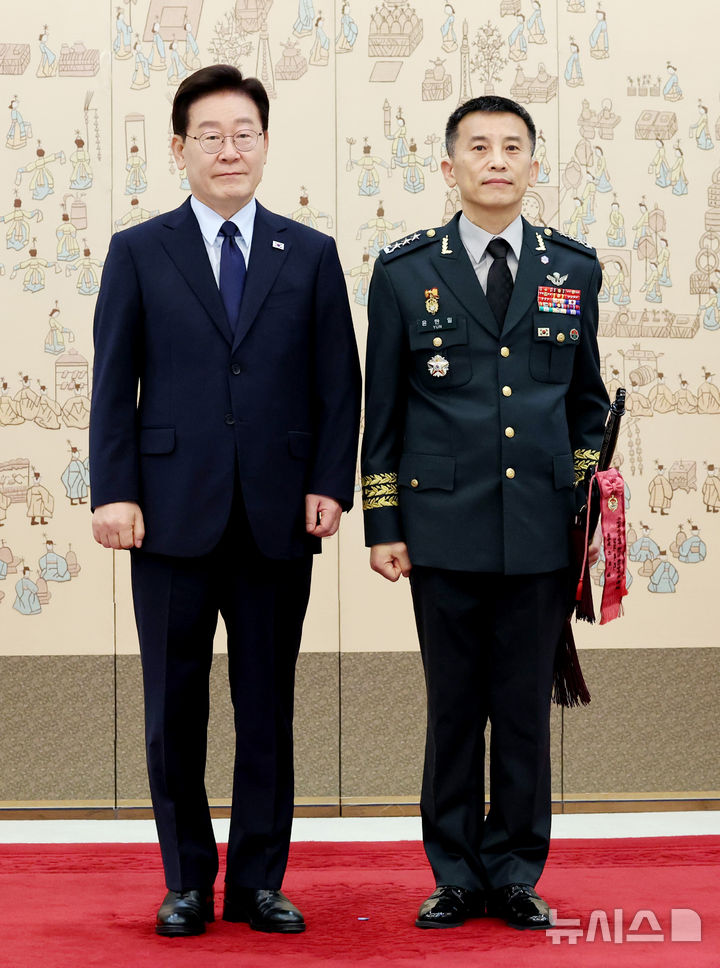 [서울=뉴시스] 김진아 기자= 이재명 대통령이 7일 청와대에서 열린 장성 진급 신고 및 삼정검 수치 수여식에서 윤한일 지상작전사령부 참모장(중장)에게 삼정검 수치를 수여한 뒤 기념촬영을 하고 있다. (청와대통신사진기자단) 2026.08.07. bluesoda@newsis.com