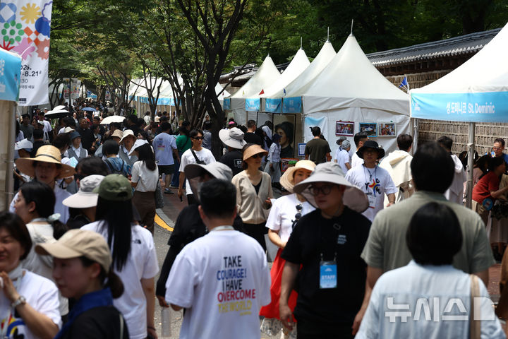 [서울=뉴시스] 고승민 기자 = 8일 서울 덕수궁 돌담길 일대에서 열린 2026 가톨릭문화박람회에서 참가자들이 부스를 둘러보고 있다. 2026.08.08. kkssmm99@newsis.com
