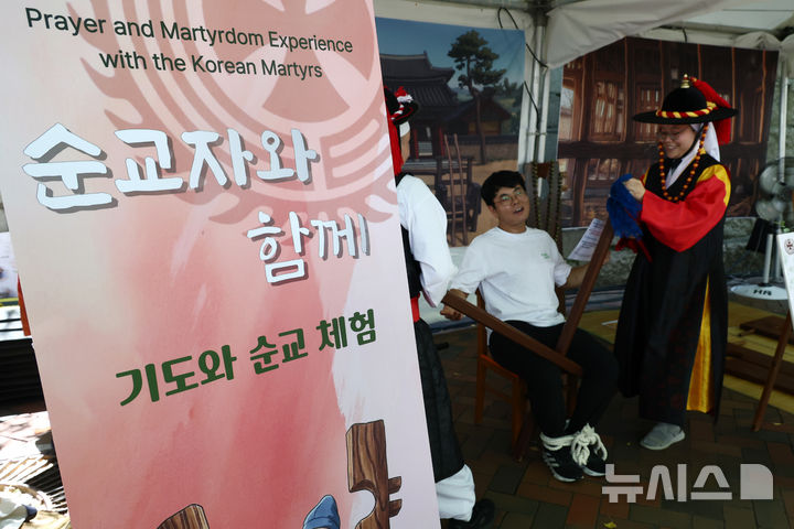 [서울=뉴시스] 고승민 기자 = 8일 서울 덕수궁 돌담길 일대에서 열린 2026 가톨릭문화박람회 에서 참가자가 순교 체험을 하고 있다. 2026.08.08. kkssmm99@newsis.com