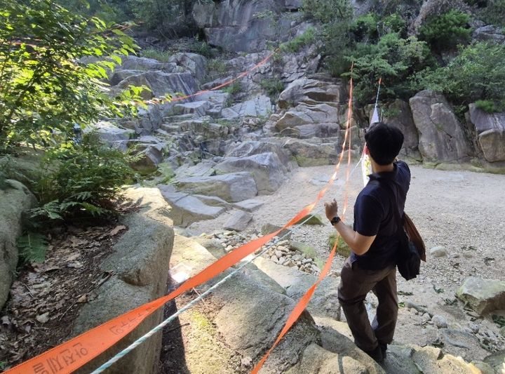 [서울=뉴시스] 관악산 상류부 입수금지 구역에 안전 관리자가 안전띠를 살피고 있다. (사진=관악구 제공) 2026.08.09. photo@newsis.com *재판매 및 DB 금지