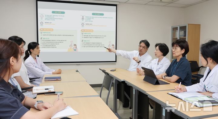 [서울=뉴시스] 서울아산병원의 중증 고령 환자 통합돌봄 시스템 '위드원'(WithONE) 서비스를 이용한 고령 환자가 5년간 1만 명을 넘어섰다. 이은주 시니어환자위원회 위원장, 손기영 통합퇴원계획팀장(오른쪽에서 세 번째, 네 번째)과 의료진이 함께 통합퇴원계획 서비스의 발전 방향에 대해 논의하고 있다. (사진= 서울아산병원 제공)
