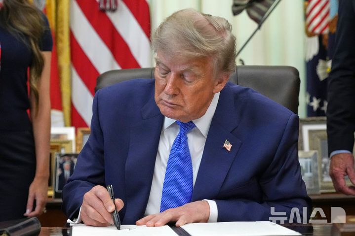 [워싱턴=AP/뉴시스] 도널드 트럼프 미국 대통령이 10일(현지 시간) 백악관 집무실에서 백신에 관한 행정명령에 서명하고 있다. 2026.08.13.