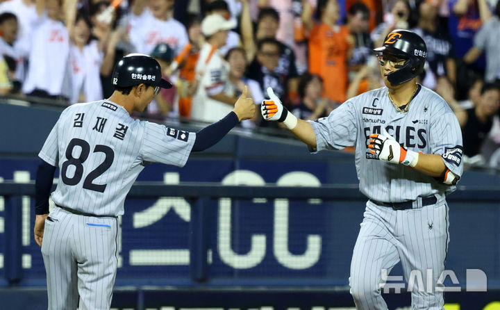 [서울=뉴시스] 전신 기자 = 11일 서울 송파구 잠실야구장에서 열린 2026 KBO 리그 한화 이글스와 두산 베어스의 경기에서 7회초 무사 1루 한화 채은성이 동점 투런 홈런을 친 뒤 그라운드를 돌며 김재걸 코치와 하이파이브를 하고 있다. 2026.08.11. photo1006@newsis.com