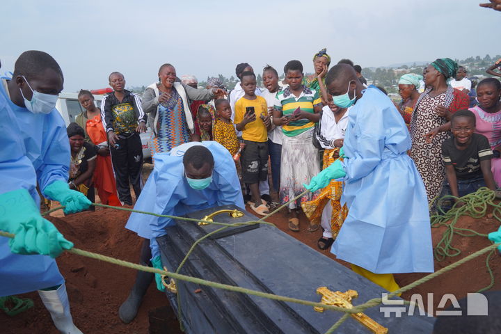 [부니아=AP/뉴시스] 8월11일 콩고민주공화국(민주콩고) 동부 이투리주 부니아에서 방호복을 입은 관계자들이 에볼라로 숨진 희생자의 유해가 담긴 관을 매장하고 있다. 아프리카CDC는 이곳 에볼라 감염이 세계 역사상 최악의 사례가 될 것이라고 8월 17일 경고했다. 2026.08.18.
