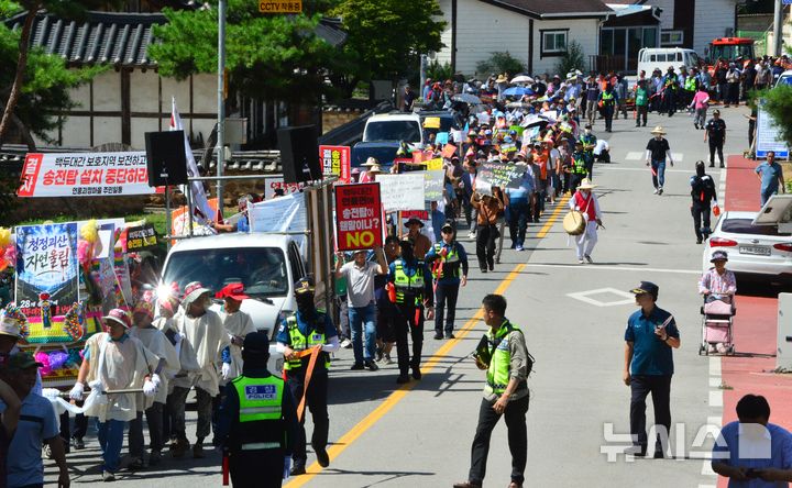 [괴산=뉴시스] 서주영 기자 = 충북 괴산군 연풍면 주민들이 12일 연풍 전통시장 일대에서 열린 송전탑 건설 반대 궐기대회에서 행진하고 있다. 주민들은 백두대간을 지나는 345㎸ 초고압 송전선로 건설계획의 중단과 경과지 재검토를 촉구했다. 2026.08.12. juyeong@newsis.com 