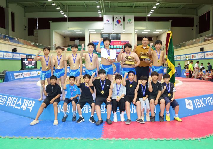 [서울=뉴시스] 12일 강원특별자치도 인제군 원통체육관에서 열린 '제4회 대한체육회장기전국장사씨름대회' 초등학교부 단체전 우승을 차지한 순천팔마초등학교(전남광주통합특별시)가 황대영 감독(윗줄 가운데)과 함께 기념사진을 찍고 있다. (사진=대한씨름협회 제공) 2026.08.12. photo@newsis.com *재판매 및 DB 금지