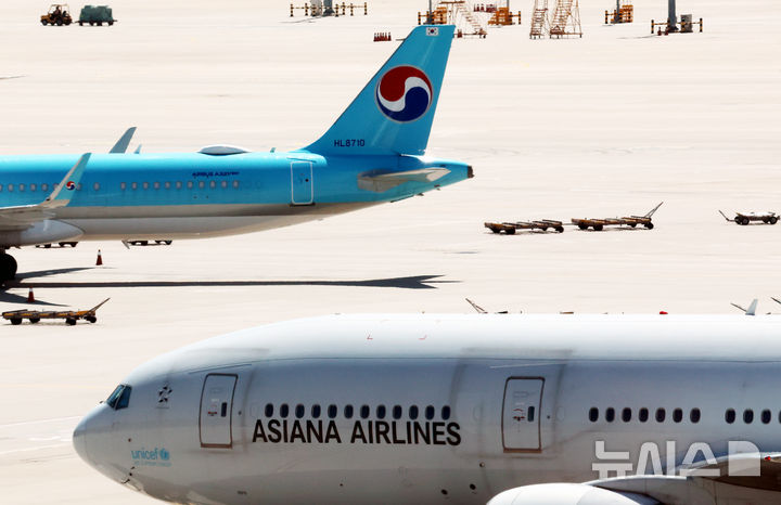 [인천공항=뉴시스] 박주성 기자 = 아시아나항공이 임시주주총회를 열고 대한항공과 합병 체결을 가결한 12일 인천국제공항 제2여객터미널 활주로에 대한항공과 아시아나 항공기가 이동하고 있다. 2026.08.12. park7691@newsis.com