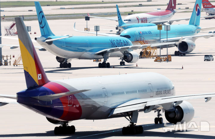 [인천공항=뉴시스] 박주성 기자 = 아시아나항공이 임시주주총회를 열고 대한항공과 합병 체결을 가결한 12일 인천국제공항 제2여객터미널 활주로에 대한항공과 아시아나 항공기가 이동하고 있다. 2026.08.12. park7691@newsis.com