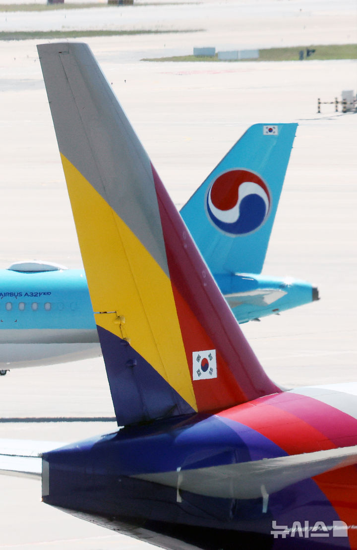 [인천공항=뉴시스] 박주성 기자 = 아시아나항공이 임시주주총회를 열고 대한항공과 합병 체결을 가결한 12일 인천국제공항 제2여객터미널 활주로에 대한항공과 아시아나 항공기가 이동하고 있다. 2026.08.12. park7691@newsis.com