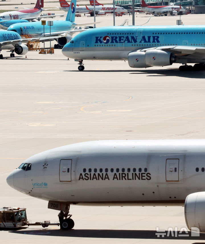 [인천공항=뉴시스] 박주성 기자 = 아시아나항공이 임시주주총회를 열고 대한항공과 합병 체결을 가결한 12일 인천국제공항 제2여객터미널 활주로에 대한항공과 아시아나 항공기가 이동하고 있다. 2026.08.12. park7691@newsis.com