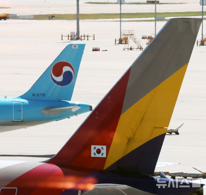 [인천공항=뉴시스] 박주성 기자 = 아시아나항공이 임시주주총회를 열고 대한항공과 합병 체결을 가결한 12일 인천국제공항 제2여객터미널 활주로에 대한항공과 아시아나 항공기가 이동하고 있다. 2026.08.12. park7691@newsis.com