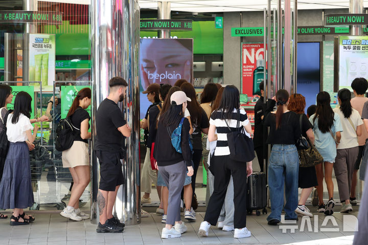 [서울=뉴시스] 이영환 기자 = 외국인 관광객들이 12일 오전 서울 중구 명동에서 상점이 오픈하자 입장하고 있다. 이날 한국관광공사에 따르면 올해 상반기 한국을 찾은 외국인 관광객은 약 1071만명으로 전년 동기 대비 21% 이상 증가했다. 이들의 국내 소비도 가파르게 늘면서 백화점부터 편의점까지 주요 유통채널이 관광객 특수를 누리고 있다. 올해 1월부터 7월까지 외국인 관광객의 국내 신용카드 소비액은 총 12조812억5976만원으로 집계됐다. 지난해 같은 기간 8조1514억7927만원과 비교하면 약 48.2% 증가한 규모다. 2026.08.12. 20hwan@newsis.com