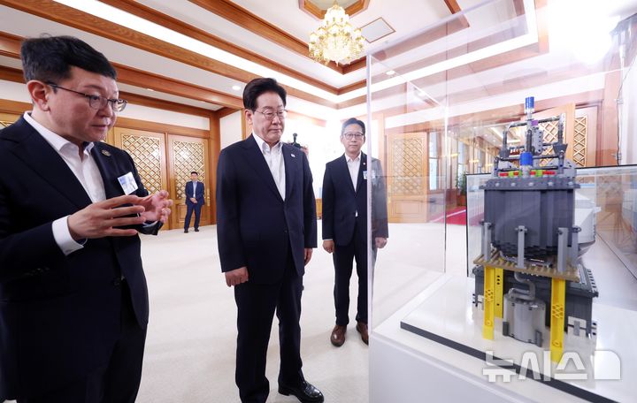 [서울=뉴시스] 조성봉 기자 = 이재명 대통령이 12일 청와대에서 열린 미래성장동력 7대 SEED 보고회에 앞서 선박용 SMR 탑재 컨테이너선 모형 관람을 하고 있다. 2026.08.12. suncho21@newsis.com