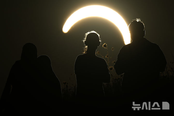 [런던=AP/뉴시스] 12일(현지 시간) 영국 런던 노살라 필즈에서 사람들이 부분일식을 관측하고 있다. 2026.08.13.