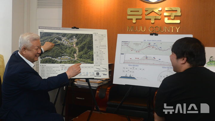 [무주=뉴시스] 김얼 기자 = 황인홍 무주군수가 현대로템 항공우주 종합생산기지 구축과 관련한 조감도 앞에서 본사 기자와 인터뷰를 하고 있다. 2026.08.13. pmkeul@newsis.com