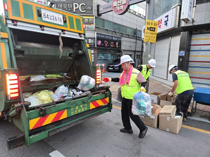 [영동=뉴시스] 정영철 충북 영동군수가 여름휴가 기간인 13일 오전 이른 시각 영동읍내 거리에서 환경미화원들과 함께 생활쓰레기를 운반하고 있다. 정 군수는 30~40분가량 영동읍내 거리에 배출된 생활폐기물을 차에 싣고 운반하며 구슬땀을 흘렸다. (사진=영동군 제공) 2026.08.13. photo@newsis.com *재판매 및 DB 금지
