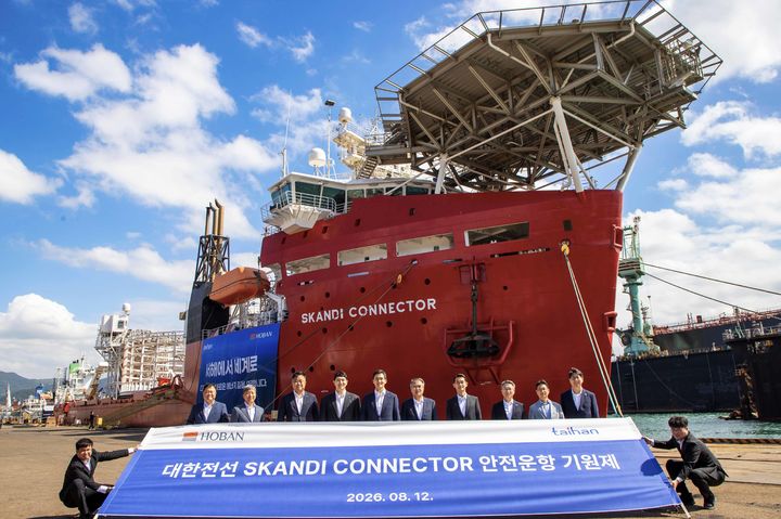 [서울=뉴시스]지난 12일 부산 감천항 오리엔트조선소에서 개최된 안전운항기원제에서 참석자들이 스칸디 커넥터호 앞에서 기념촬영을 하고 있다. 왼쪽 네번째부터 김민성 호반그룹 부사장, 김대헌 호반그룹 기획총괄사장, 송종민 대한전선 부회장, 김준석 대한전선 부사장. (사진=대한전선 제공) 2026.08.13. photo@newsis.com *재판매 및 DB 금지