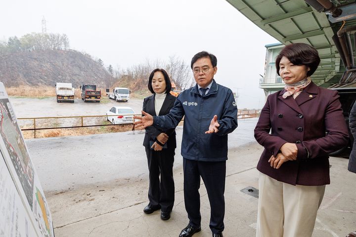 [서울=뉴시스] 진교훈 서울 강서구청장(가운데)이 한정애 국회의원 등과 함께 국토교통부가 8월13일 주택공급사업지로 발표한 염창근린공원 훼손지를 찾아 현황 자료를 살펴보고 있다. (사진=서울 강서구 제공) 2026.08.13. photo@newsis.com *재판매 및 DB 금지