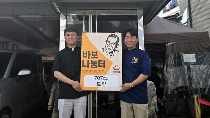 [서울=뉴시스] 임태훈 셰프와 김인권 상임이사 신부(왼쪽)가 '바보나눔터' 현판을 들고 기념촬영을 하고 있다. (사진= 바보의나눔 제공) 2026.08.13. photo@newsis.com *재판매 및 DB 금지
