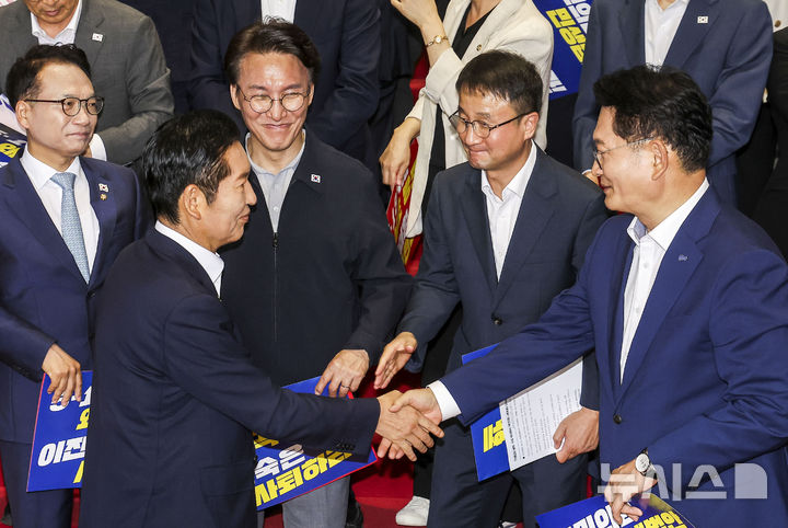 [서울=뉴시스] 정병혁 기자 = 송영길, 정청래, 김민석 더불어민주당 당대표 후보가 13일 서울 여의도 국회 로텐더홀 계단에서 민생입법 방해, 5.18 역사 왜곡 국민의힘 규탄대회를 마친 뒤 악수를 하고 있다. 2026.08.13. jhope@newsis.com