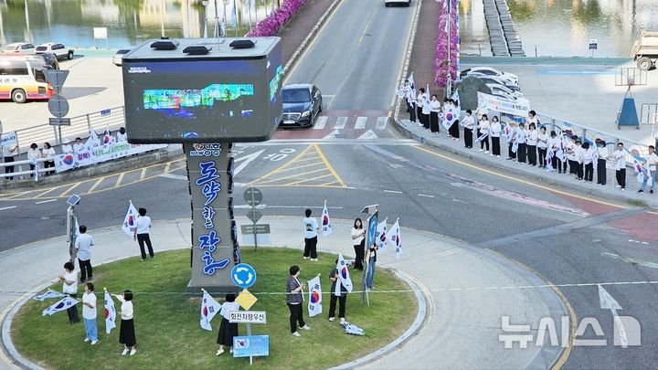 [장흥=뉴시스] 이창우 기자=13일 전남광주특별시 장흥군·읍 일대에서 광복회 장흥연합지회와 장흥종합사회복지관, 샛별지역아동센터, 군 관계자 등 200여명이 참여한 가운데 열린 '태극기 달기 캠페인'을 펼치고 있다. (사진=장흥군 제공) photo@newsis.com