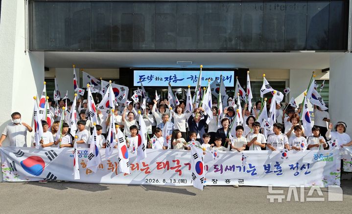 [장흥=뉴시스] 이창우 기자=13일 전남광주특별시 장흥군·읍 일대에서 광복회 장흥연합지회와 장흥종합사회복지관, 샛별지역아동센터, 군 관계자 등 200여명이 참여한 가운데 열린 '태극기 달기 캠페인'을 펼치고 있다. (사진=장흥군 제공) photo@newsis.com