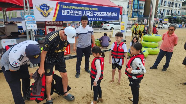 [당진=뉴시스] 평택해양경찰서가 14일 충남 당진 왜목마을해수욕장을 찾아 구명조끼 착용 홍보부스를 만든 뒤 피서객을 대상으로 구명조끼의 올바른 착용법을 교육하고 있다. (사진=평택해양경찰서 제공) 2026.08.14. photo@newsis.com *재판매 및 DB 금지