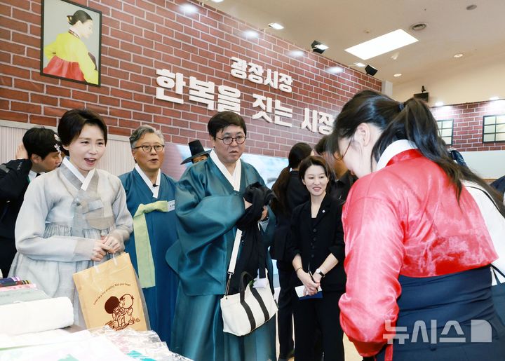 [서울=뉴시스] 조성봉 기자 = 김혜경 여사가 14일 서울 동대문디자인플라자(DDP)에서 열린 2026 한복상점 전시회에서 한복을 입은 시민들과 인사하고 있다. 왼쪽부터 김혜경 여사, 김경배 한국·공예디자인문화진흥원장, 최휘영 문화체육관광부 장관, 안귀령 부대변인. (청와대통신사진기자단) 2026.08.14. suncho21@newsis.com