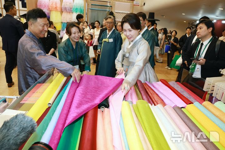 [서울=뉴시스] 조성봉 기자 = 김혜경 여사가 14일 서울 동대문디자인플라자(DDP)에서 열린 2026 한복상점 전시회에서 원단을 살펴보고 있다. (청와대통신사진기자단) 2026.08.14. suncho21@newsis.com