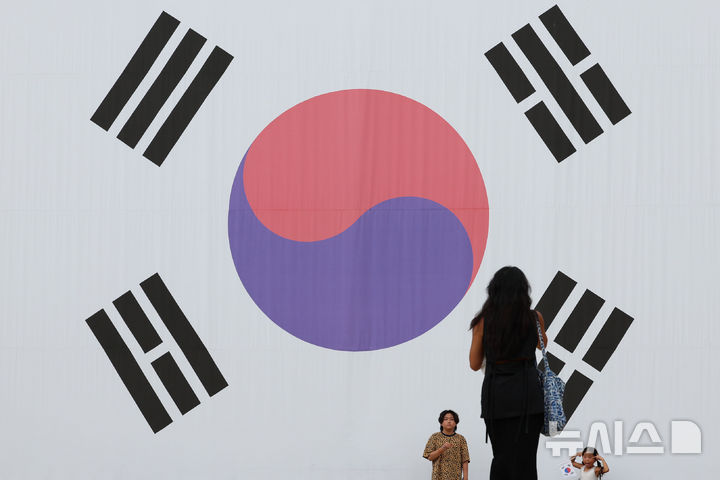 [서울=뉴시스] 권창회 기자 = 광복절을 하루 앞둔 14일 서울 서대문구 서대문형무소 역사관 대형태극기 앞에서 시민들이 사진을 찍고 있다. 2026.08.14. kch0523@newsis.com