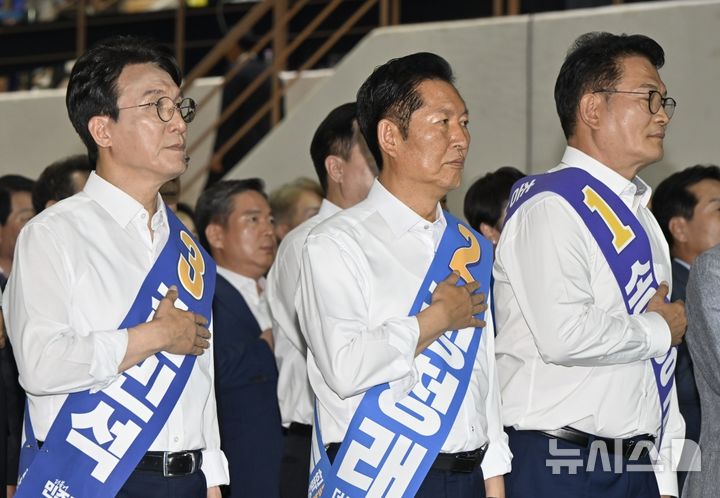 [나주=뉴시스] 양시원 기자 = 김민석(왼쪽부터), 정청래, 송영길 더불어민주당 당대표 후보가 15일 전남광주 나주시 종합스포츠파크 다목적체육관에서 열린 당대표 및 최고위원 후보자 선출을 위한 전남광주 합동연설회에서 국민의례를 하고 있다. 2026.08.15. goodwrite97@newsis.com