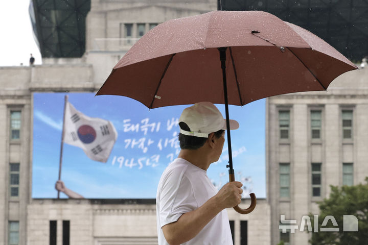 [서울=뉴시스] 최동준 기자 = 광복절 연휴가 시작된 지난 15일 서울 중구 서울시청 앞에서 시민이 우산을 쓰고 길을 걷고 있다. 2026.08.15. photocdj@newsis.com