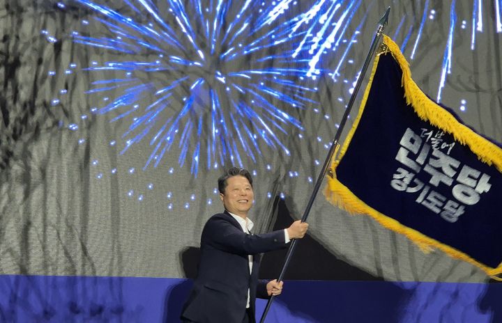 [수원=뉴시스] 이병희 기자 = 서영석 신임 더불어민주당 경기도당위원장이 16일 수원종합운동장 실내체육관에서 열린 정기경기도당당원대회에서 도당위원장으로 선출된 뒤 당기를 흔들고 있다. 2026.08.16. iambh@newsis.com *재판매 및 DB 금지