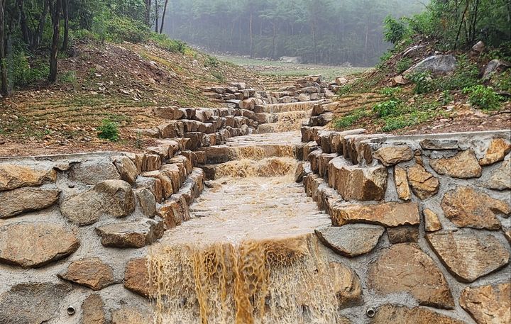 [산청=뉴시스] 서희원 기자 = 16일 지난해 경남 산청군 신안면 외송리 국도 3호선을 넘어 구 경호강 휴게소를 덮친 산사태지역에 복구공사가 완료돼 단비가 하천으로 흐르고 있다. 2026.08.16. shw1881@newsis.com *재판매 및 DB 금지