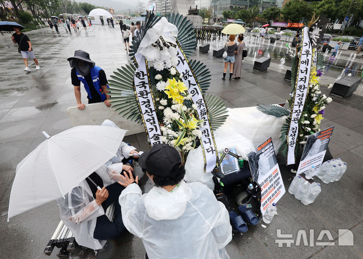 [서울=뉴시스] 조성우 기자 = 전국가습기살균제참사피해자연대가 16일 서울 종로구 광화문광장에서 고 서영철 피해자연대 대표의 빈소 천막 설치를 두고 서울시 관계자들과 대치하고 있다. 2026.08.16. xconfind@newsis.com