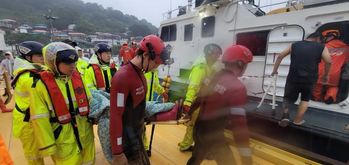 [통영=뉴시스] 신정철 기자= 17일 오전 5시 3분께 경남 통영시 산양읍 곤리도에서 갑자기 쏟아진 폭우로 산사태가 발생, 주민 1명이 매몰됐다. 사진은 통영해양경찰서 구조대원들이 자택 화장실에 매몰된 A 씨(64·여)를 구조하여 경비함정으로 육지 병원으로 이송하고 있다.(사진=통영해경 제공).2026.08.17. photo@newsis.com *재판매 및 DB 금지