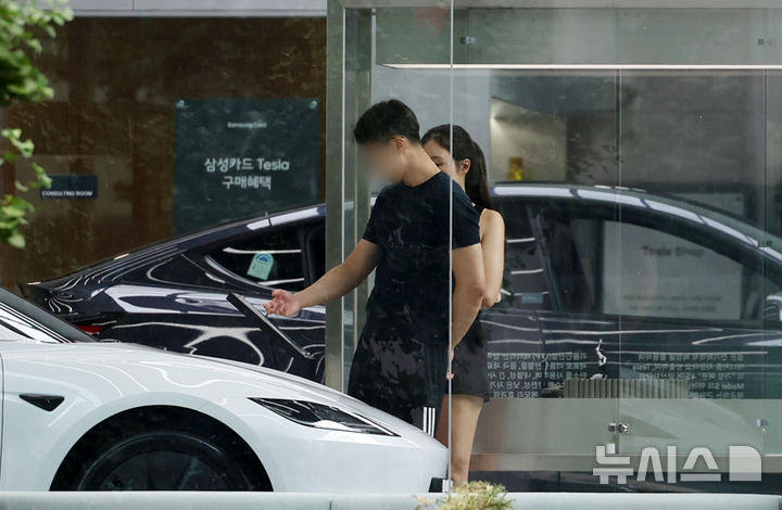 [서울=뉴시스] 조성우 기자 = 중고차 시장 전체 시세가 하락세로 돌아선 가운데 테슬라를 필두로 한 전기차와 하이브리드 차종의 중고차 가격은 상승세를 보이고 있다. 테슬라는 첨단 주행 보조 시스템인 FSD 도입에 대한 기대감이 시세를 견인하고 있다. 17일 서울 시내 테슬라 매장에서 시민들이 차량을 살펴보고 있다.엔카닷컴에 따르면 2023년식·주행거리 6만km·무사고 기준 대표 37개 모델의 8월 평균 중고차 시세는 전월 대비 1.43% 하락했다. 반면 테슬라 모델3 롱레인지 AWD와 모델Y 롱레인지 AWD는 각각 3.32%, 3.05% 상승했다. 2026.08.17. xconfind@newsis.com