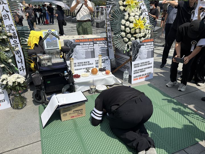 [서울=뉴시스] 김나연 수습기자 = 고(故) 서영철 전국가습기살균제참사피해자연대 대표의 아들이 18일 서울 광화문광장에서 부친의 영정을 향해 절하는 모습. 2026.08.18. photo@newsis.com *재판매 및 DB 금지