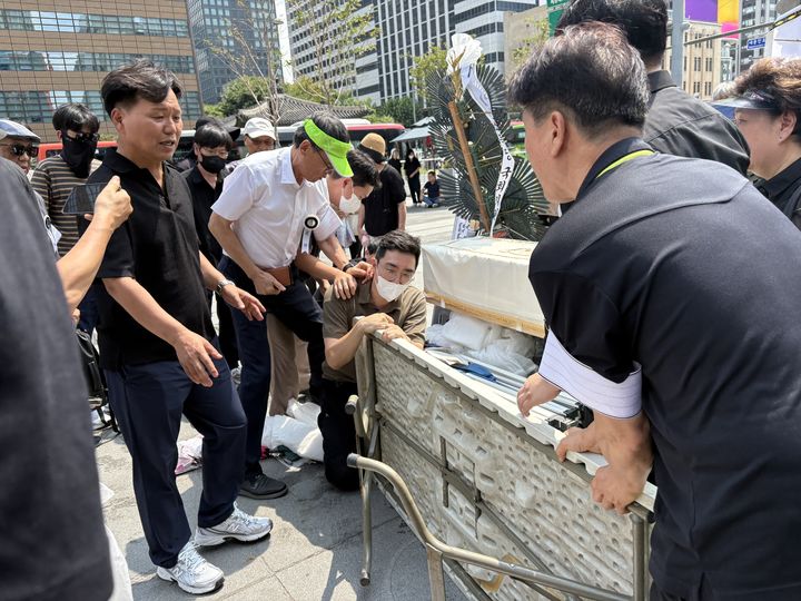[서울=뉴시스] 김나연 수습기자 = 전국가습기살균제참사피해자연대와 서울시 관계자들이 18일 서울 광화문광장에 천막을 설치하는 것을 두고 실랑이하고 있다. 2026.08.18. photo@newsis.com *재판매 및 DB 금지