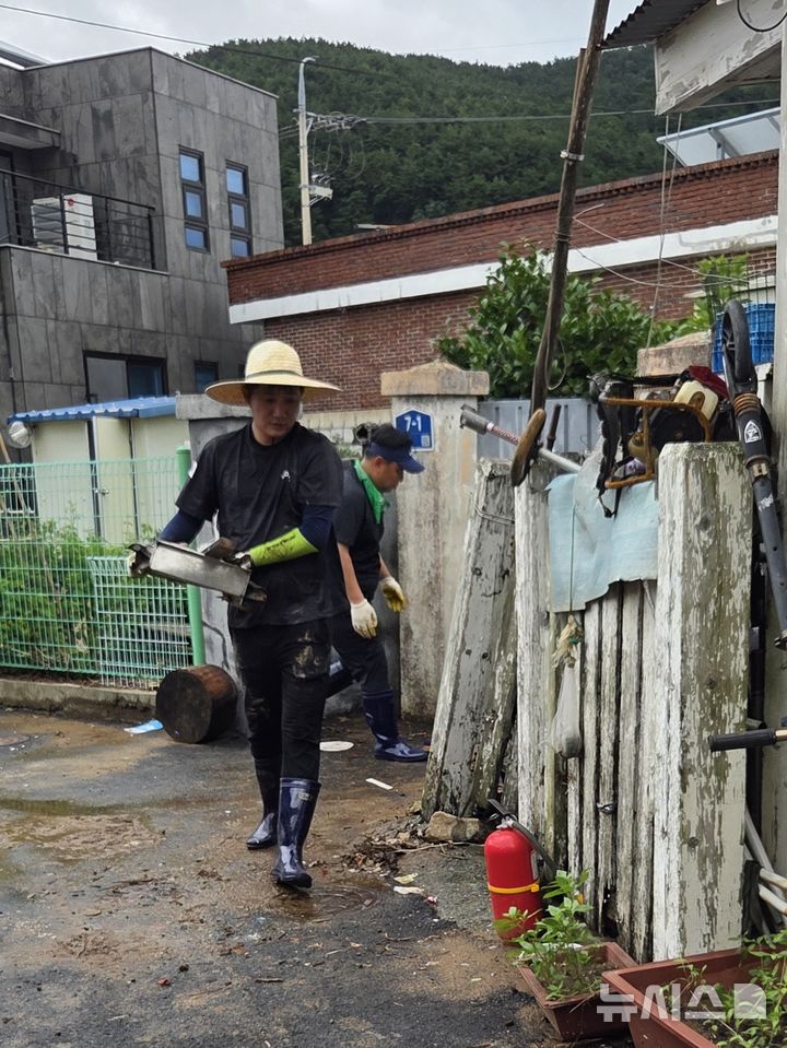 [거제=뉴시스]경남도의회 더불어민주당 김경수 대표의원 등 원내대표단이 18일 집중호우로 침수 피해가 발생한 거제시 일운면 회진마을을 찾아 가재도구 정리등 복구 지원 활동을 하고 있다.(사진=경남도의회 제공) 2026.08.18. photo@newsis.com