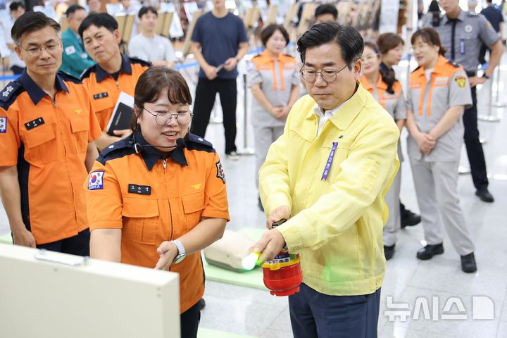 [인천=뉴시스] 박찬대 인천시장이 18일 인천시청 본관 중앙홀에서 열린 '시민과 함께하는 을지연습' 연계 소방안전체험 행사에서 소화기 사용법을 익히고 있다. (사진=인천소방본부 제공) 2026.08.18. photo@newsis.com