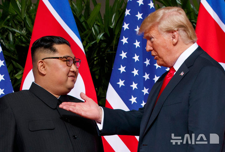 [싱가포르=AP/뉴시스]도널드 트럼프 미국 대통령이 김정은 북한 국무위원장과의 연내 회담을 추진하고 있다는 미국 언론 보도가 나왔다. 11월 중국 선전에서 열리는 아시아태평양경제협력체(APEC) 정상회의 계기 회담 가능성이 제기된다. 사진은 2018년 6월12일 트럼프 대통령과 김 위원장이 싱가포르 센토사섬에서 만난 모습. 2026.08.19.