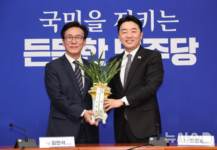 [서울=뉴시스] 최진석 기자 = 김민석(왼쪽) 더불어민주당 대표가 18일 여의도 국회에서 강훈식 대통령비서실 비서실장과 접견하며 이재명 대통령이 보낸 축하 난을 받고 있다. 2026.08.18. myjs@newsis.com