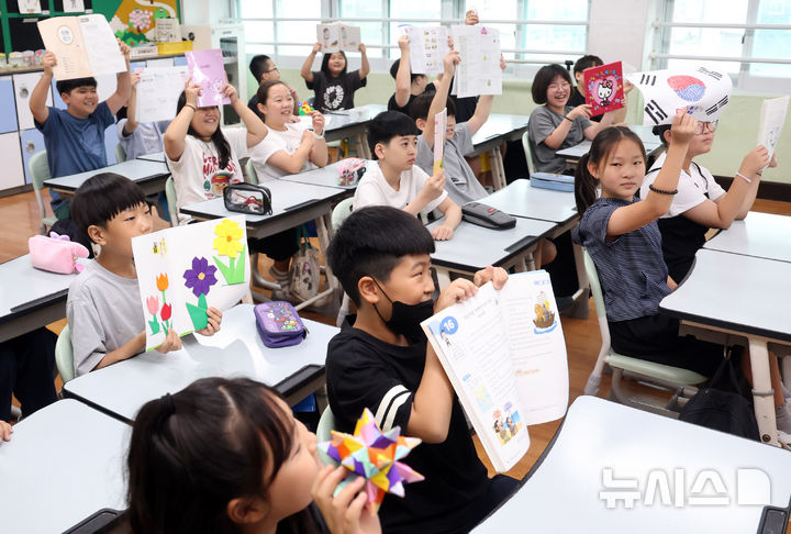 [부산=뉴시스] 하경민 기자 = 2026학년도 2학기 개학식이 열린 8월 18일 부산 영도구 대평초등학교 4학년 2반 교실에서 학생들이 여름방학 과제를 들어보이며 교사와 인사하고 있다. 2026.08.18. yulnetphoto@newsis.com