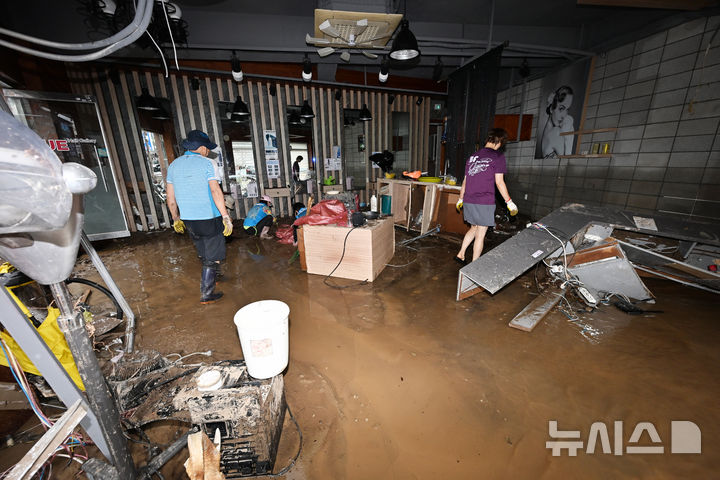 [거제=뉴시스] 차용현 기자 = 18일 오전 기록적인 폭우로 큰 피해가 발생한 경남 거제시 옥포동 일대에서 주민들이 침수된 상가와 주택 등에 쌓인 토사와 물에 젖은 집기류를 치우며 수해 복구 작업을 벌이고 있다. 2026.08.18. con@newsis.com
