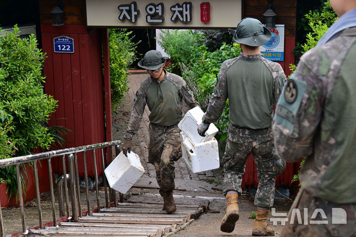 [통영=뉴시스] 차용현 기자 = 18일 오후 폭우 피해를 입은 경남 통영시 봉평동에서 육군 39사단 8358부대 장병들이 수해 복구작업을 벌이고 있다. 장병들은 군복이 진흙으로 범벅이 된 채 무거운 수해 잔해와 집기류를 옮기며 피해 복구에 구슬땀을 흘렸다. 2026.08.18. con@newsis.com