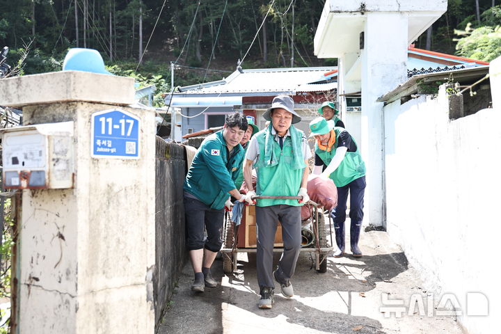 [거제=뉴시스] 박완수 경남도지사가 19일 거제시 연초면 침수 주택가를 찾아 못쓰게 된 가재도구, 생활용품 등을 실은 리어카를 끌고 있다. (사진=경남도 제공) 2026.08.19. photo@newsis.com