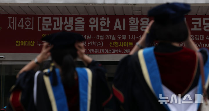 [서울=뉴시스] 김금보 기자 = 19일 서울 시내 한 대학교에서 학사모를 고쳐쓰는 졸업생들 앞으로 문과생을 위한 AI활용 워크샵 안내 현수막이 걸려있다. 2026.08.19. kgb@newsis.com