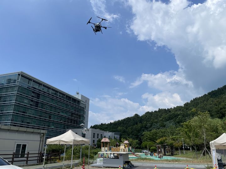 [서울=뉴시스]우주항공청이 한국전자통신연구원(ETRI)과 함께 개발한 드론·로봇 협업 기반 고중량 화물 비대면 배송 운용체계를 경남 사천 지역에서 실증했다. (사진=우주항공청 제공) *재판매 및 DB 금지